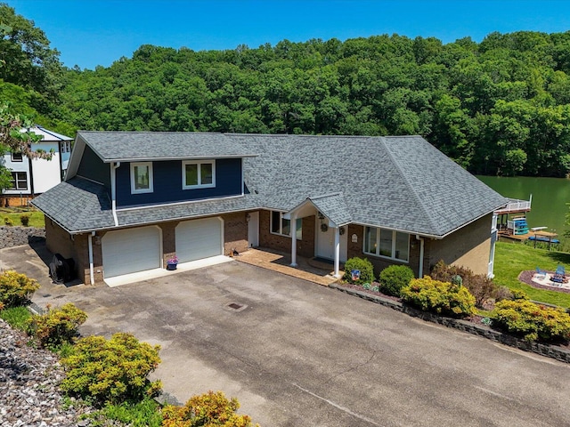 285 Dixon Dr, Hardy, VA 24101 - view of front of home featuring a garage, a wooded view, brick siding, and roof with shingles