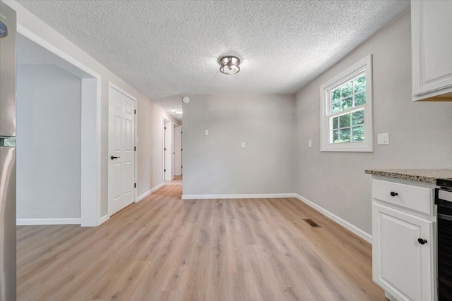 1632 Haymakertown Rd, Troutville, VA 24175 - unfurnished dining area featuring light wood-type flooring, a textured ceiling, and baseboards