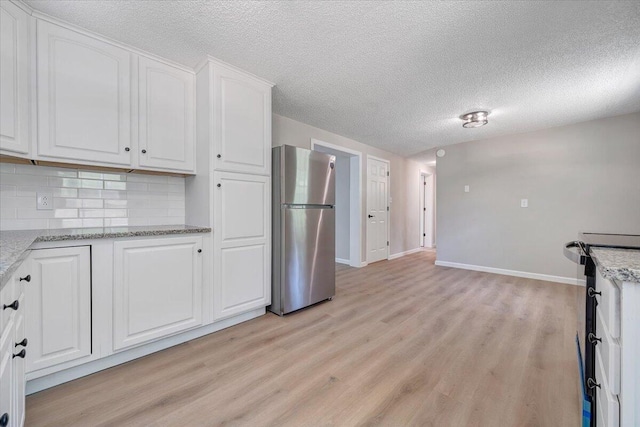 1632 Haymakertown Rd, Troutville, VA 24175 - kitchen featuring freestanding refrigerator, light wood-style floors, white cabinetry, backsplash, and baseboards