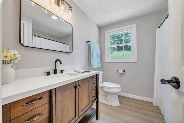 1632 Haymakertown Rd, Troutville, VA 24175 - full bath with wood finished floors, vanity, toilet, a textured ceiling, and baseboards
