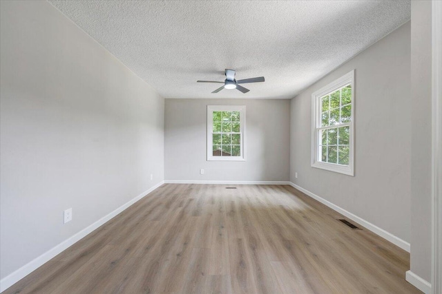 1632 Haymakertown Rd, Troutville, VA 24175 - spare room featuring plenty of natural light, wood finished floors, a ceiling fan, a textured ceiling, and baseboards