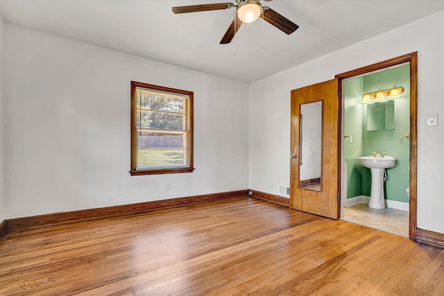 2527 Northminster Rd NW, Roanoke, VA 24012 - unfurnished bedroom featuring light wood-style floors, a sink, baseboards, a ceiling fan, and ensuite bath