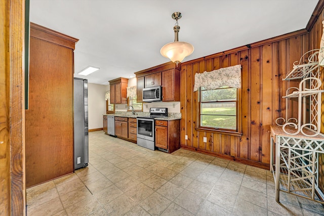 2527 Northminster Rd NW, Roanoke, VA 24012 - kitchen featuring appliances with stainless steel finishes, baseboards, wooden walls, a sink, and light stone counters