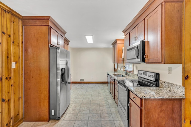 2527 Northminster Rd NW, Roanoke, VA 24012 - kitchen with stainless steel appliances, baseboards, a sink, light stone countertops, and stone finish floors