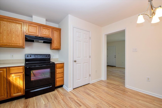 1903 Archbold Ave NE, Roanoke, VA 24012 - kitchen with under cabinet range hood, black electric range, a chandelier, light wood-style floors, and light countertops