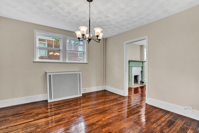 1132 Hamilton Ave SW, Roanoke, VA 24015 - empty room with a fireplace with flush hearth, wood finished floors, and a chandelier