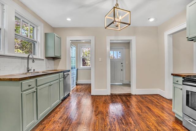 1132 Hamilton Ave SW, Roanoke, VA 24015 - kitchen with green cabinets, butcher block counters, appliances with stainless steel finishes, decorative backsplash, and dark wood-style floors