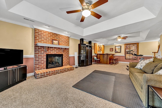 6355 Juliet Ct, Roanoke, VA 24018 - carpeted living room featuring a tray ceiling, a bar, crown molding, a ceiling fan, and a brick fireplace
