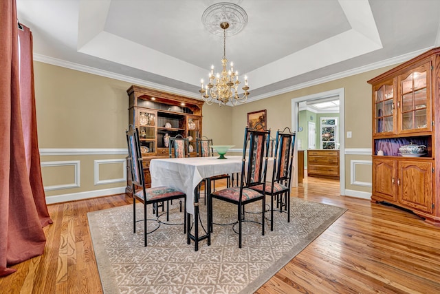 6355 Juliet Ct, Roanoke, VA 24018 - dining room with a chandelier, a raised ceiling, light wood finished floors, a wainscoted wall, and crown molding