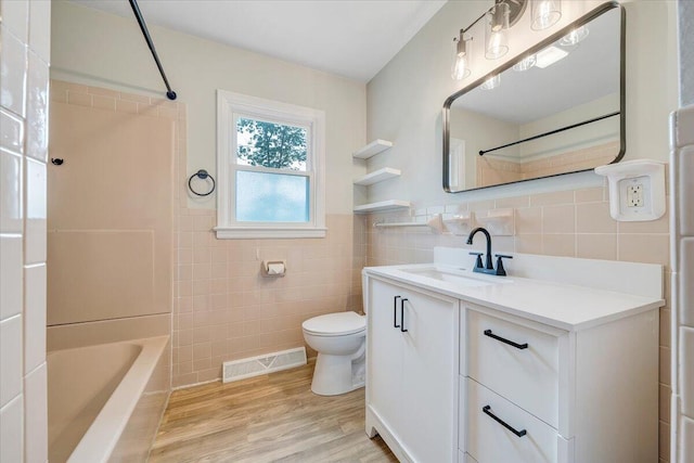 3271 Rasmont Rd, Roanoke, VA 24018 - full bathroom featuring tile walls, vanity, toilet, wood finished floors, and washtub / shower combination