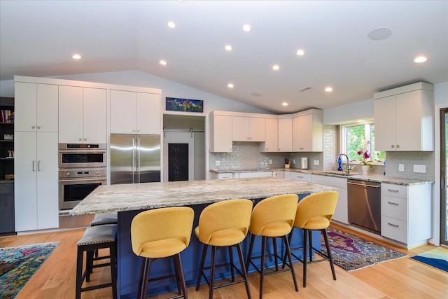 569 Sprinkle Rd, Fincastle, VA 24090 - kitchen featuring stainless steel appliances, a center island, a sink, lofted ceiling, and tasteful backsplash