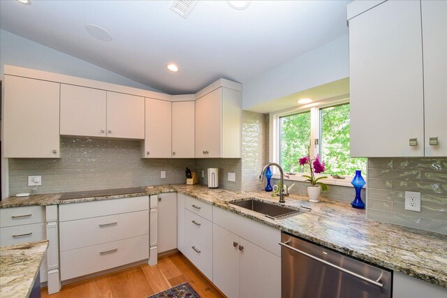 569 Sprinkle Rd, Fincastle, VA 24090 - kitchen featuring stainless steel dishwasher, a sink, black electric cooktop, vaulted ceiling, and white cabinetry