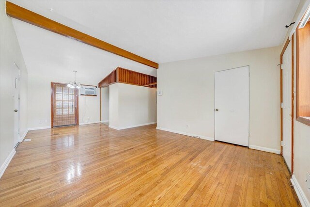 1046 Silverwood Rd NW, Roanoke, VA 24017 - unfurnished living room featuring a chandelier, light wood-style floors, and a wall unit AC