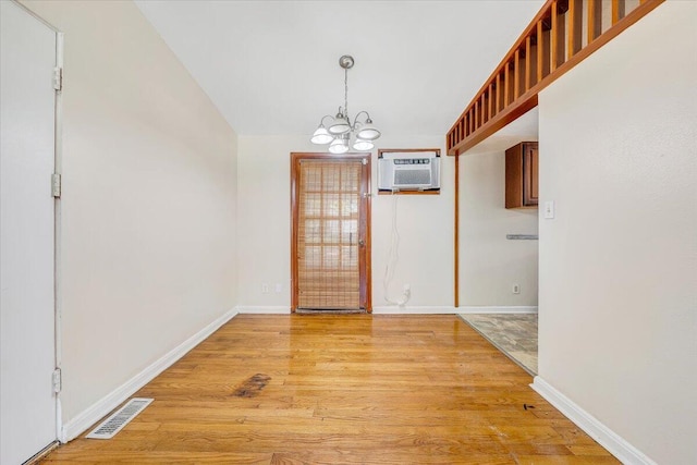 1046 Silverwood Rd NW, Roanoke, VA 24017 - unfurnished dining area with a chandelier, light wood finished floors, and an AC wall unit