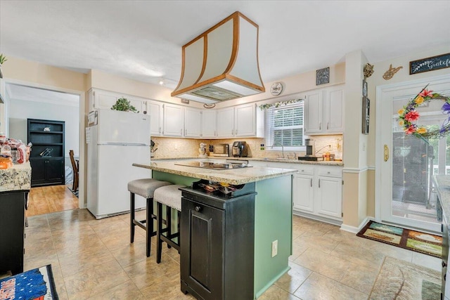 201 Jay Ridge Rd, Cloverdale, VA 24077 - kitchen featuring freestanding refrigerator, white cabinetry, backsplash, a center island, and a sink