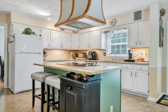 201 Jay Ridge Rd, Cloverdale, VA 24077 - kitchen with freestanding refrigerator, black electric cooktop, a sink, white cabinetry, and decorative backsplash