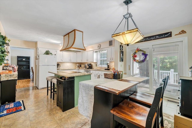 201 Jay Ridge Rd, Cloverdale, VA 24077 - kitchen featuring freestanding refrigerator, a center island, a sink, white cabinets, and a breakfast bar