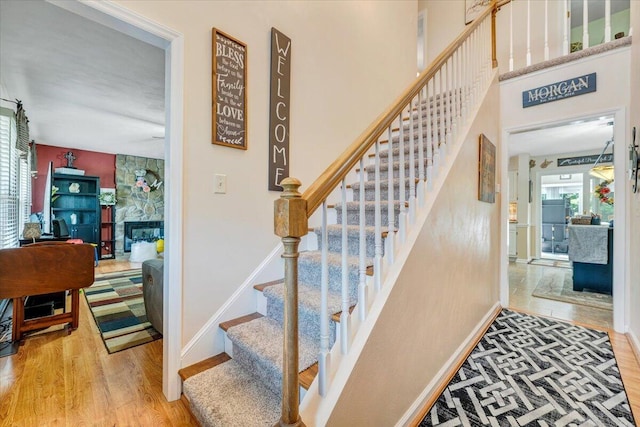 201 Jay Ridge Rd, Cloverdale, VA 24077 - stairway with wood finished floors, baseboards, and a stone fireplace