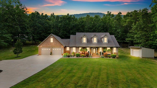 5335 Catawba Valley Dr, Catawba, VA 24070 - cape cod-style house with covered porch, concrete driveway, a yard, a garage, and brick siding