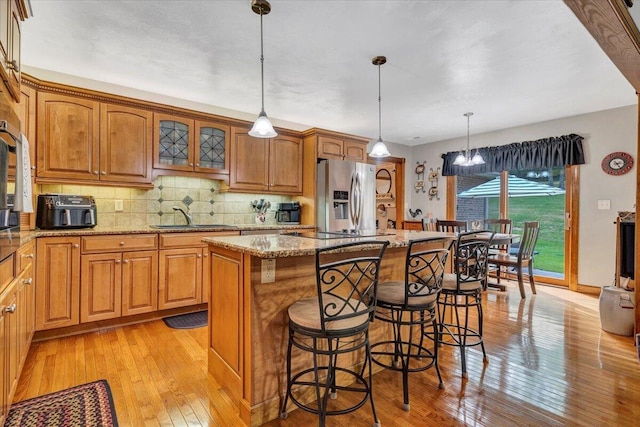 5335 Catawba Valley Dr, Catawba, VA 24070 - kitchen with stainless steel fridge, light wood-type flooring, a kitchen island, and a breakfast bar