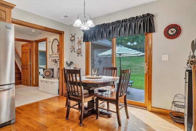 5335 Catawba Valley Dr, Catawba, VA 24070 - dining space featuring light wood finished floors, a chandelier, and stairs