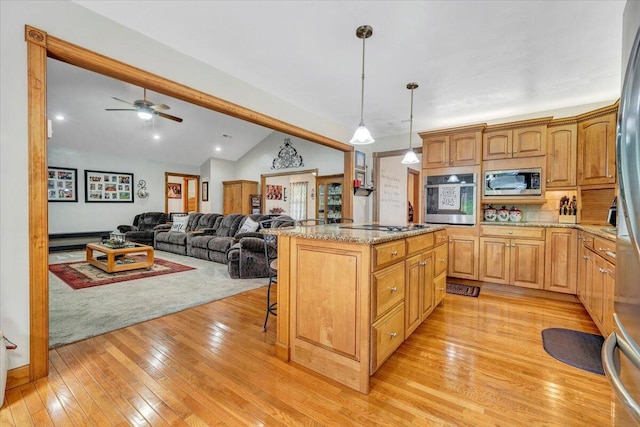5335 Catawba Valley Dr, Catawba, VA 24070 - kitchen featuring appliances with stainless steel finishes, light wood finished floors, lofted ceiling, a breakfast bar, and light stone counters