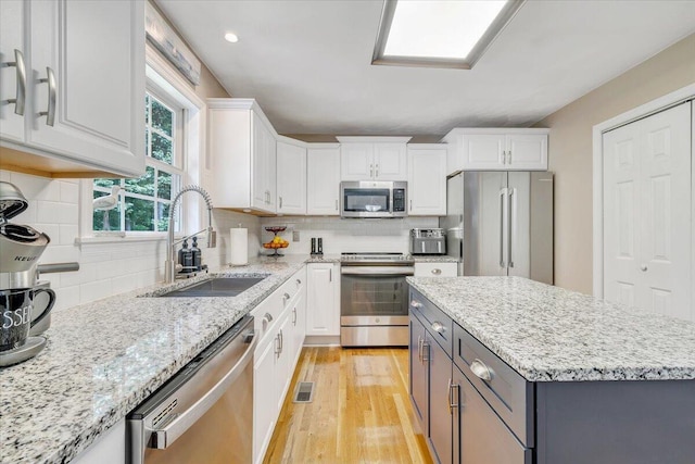 139 Lynville Dr, Hardy, VA 24101 - kitchen with appliances with stainless steel finishes, a sink, white cabinetry, light wood-style floors, and gray cabinets