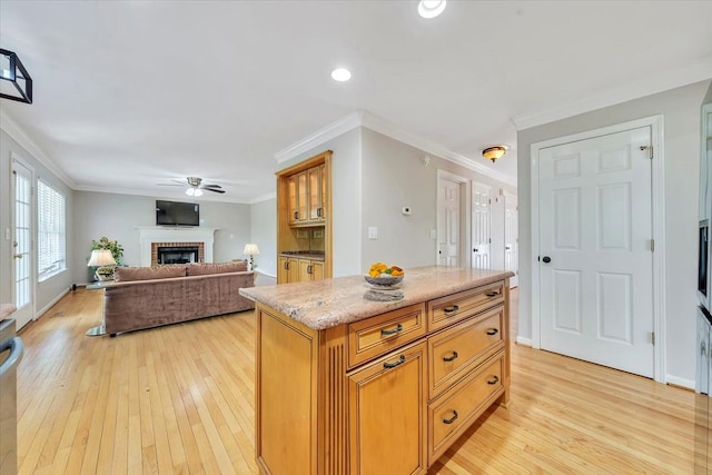 6061 Chagall Dr, Roanoke, VA 24018 - kitchen featuring a fireplace, light wood finished floors, ceiling fan, ornamental molding, and a center island