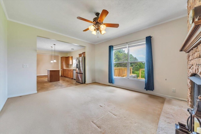 60 Tara Dr, Ridgeway, VA 24148 - unfurnished living room featuring ornamental molding, a ceiling fan, light colored carpet, baseboards, and a stone fireplace