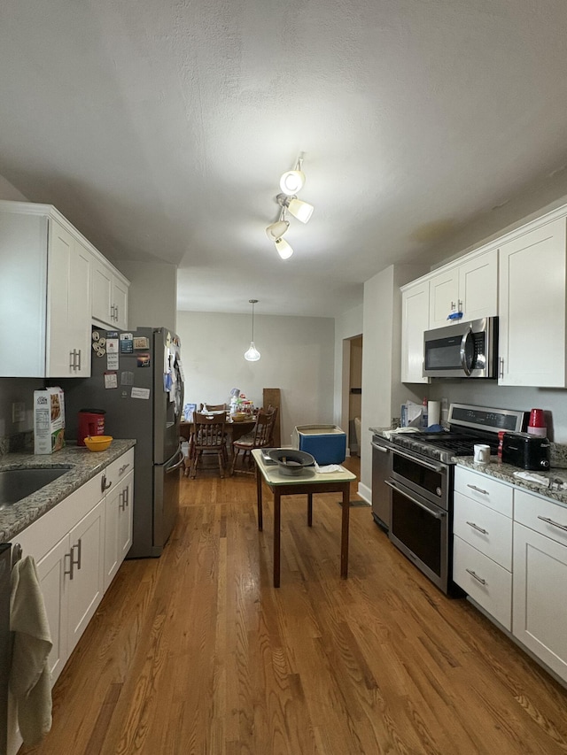 423 Turner Rd, Salem, VA 24153 - kitchen with stainless steel appliances, white cabinets, light stone counters, and pendant lighting