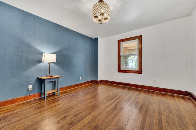1618 8th St SE, Roanoke, VA 24013 - spare room with wood-type flooring, a chandelier, and baseboards