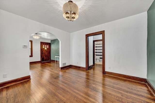 1618 8th St SE, Roanoke, VA 24013 - spare room featuring arched walkways, a chandelier, wood-type flooring, and baseboards