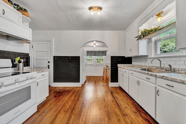 1618 8th St SE, Roanoke, VA 24013 - kitchen with white stove, arched walkways, backsplash, and white cabinetry