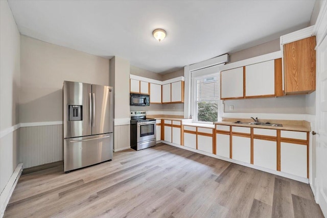 1523 Rorer Ave SW, Roanoke, VA 24016 - kitchen featuring appliances with stainless steel finishes, baseboard heating, light wood finished floors, and light countertops