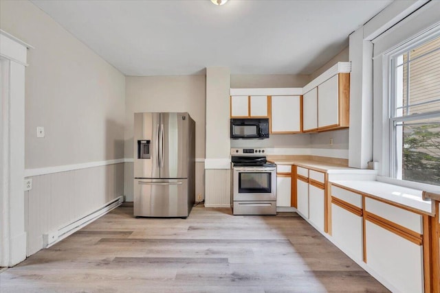 1523 Rorer Ave SW, Roanoke, VA 24016 - kitchen featuring stainless steel appliances, a baseboard heating unit, plenty of natural light, light countertops, and a wainscoted wall