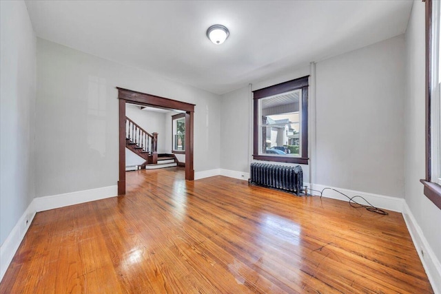 1523 Rorer Ave SW, Roanoke, VA 24016 - empty room featuring radiator, stairs, wood finished floors, and baseboards