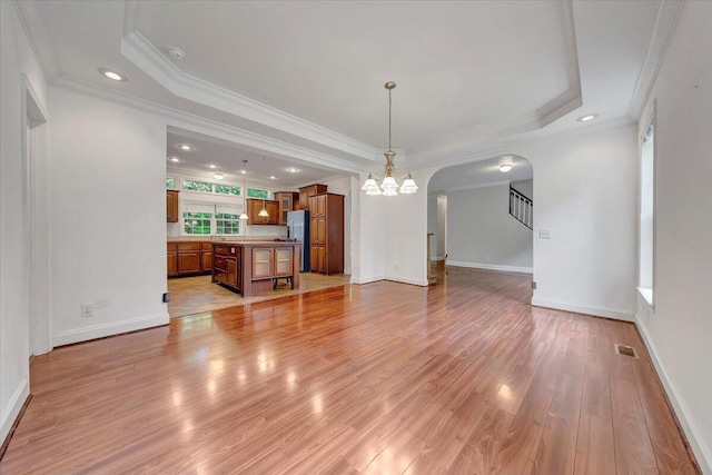 5995 Twine Hollow Rd, Salem, VA 24153 - unfurnished living room with a chandelier, crown molding, a raised ceiling, light wood-style floors, and arched walkways