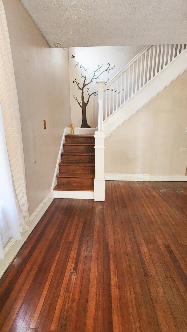 611 Alleghany St, Clifton Forge, VA 24422 - staircase with hardwood / wood-style flooring, baseboards, and a textured ceiling
