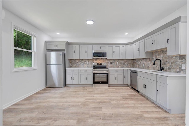 496 Boyd St, Buchanan, VA 24066 - kitchen with stainless steel appliances, backsplash, light countertops, gray cabinets, and light wood finished floors