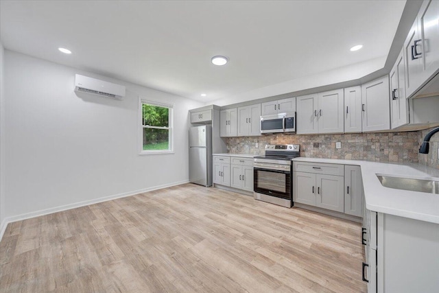 496 Boyd St, Buchanan, VA 24066 - kitchen featuring appliances with stainless steel finishes, a wall unit AC, light countertops, decorative backsplash, and light wood finished floors