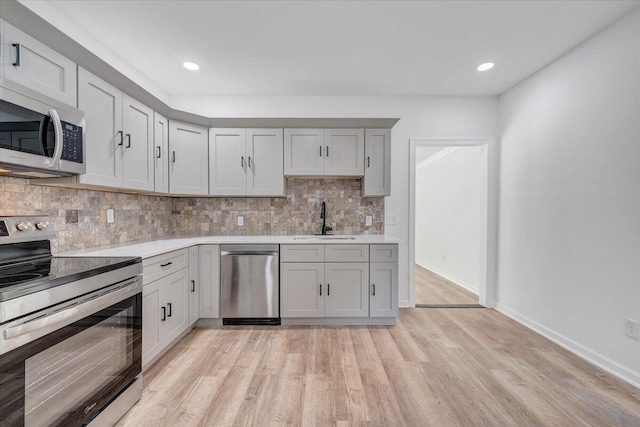 496 Boyd St, Buchanan, VA 24066 - kitchen with stainless steel appliances, light countertops, light wood-style floors, decorative backsplash, and recessed lighting