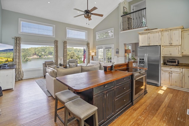 800 Long Island Dr, Moneta, VA 24121 - kitchen featuring appliances with stainless steel finishes, high vaulted ceiling, cream cabinets, butcher block countertops, and light wood-style floors