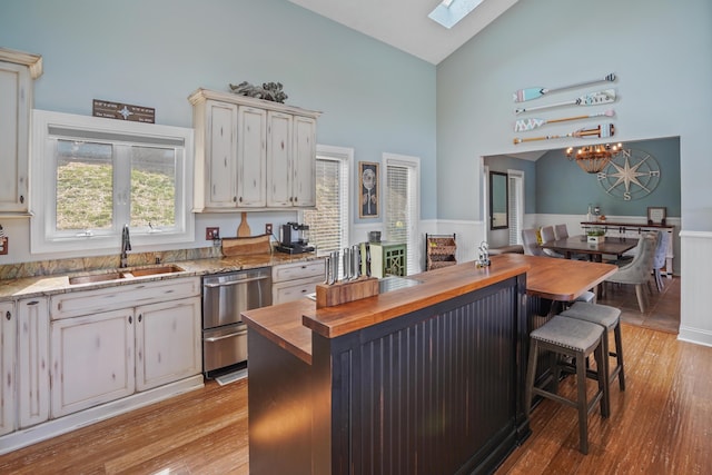 800 Long Island Dr, Moneta, VA 24121 - kitchen with butcher block counters, stainless steel dishwasher, high vaulted ceiling, light wood finished floors, and a breakfast bar area
