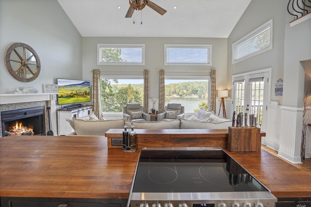 800 Long Island Dr, Moneta, VA 24121 - kitchen featuring wood counters, high vaulted ceiling, ceiling fan, a lit fireplace, and stove
