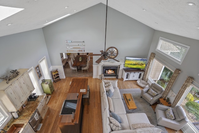 800 Long Island Dr, Moneta, VA 24121 - living area featuring high vaulted ceiling, wood finished floors, a lit fireplace, a ceiling fan, and recessed lighting