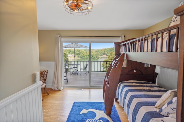 800 Long Island Dr, Moneta, VA 24121 - bedroom featuring access to outside, wood finished floors, wainscoting, a chandelier, and a water view