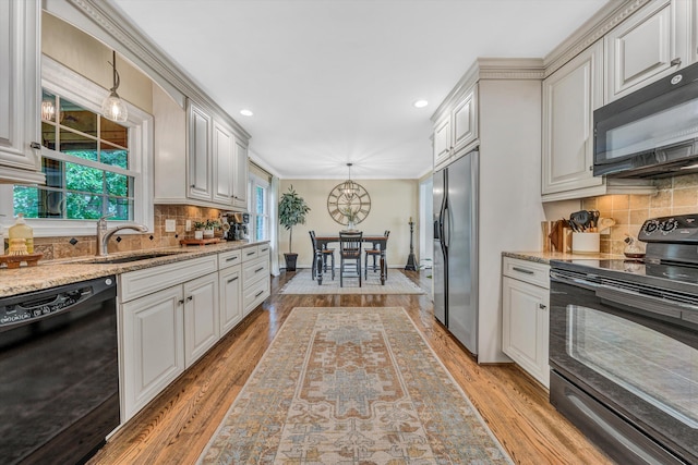 134 Sawyer Dr, Salem, VA 24153 - kitchen featuring black appliances, backsplash, light wood-style flooring, decorative light fixtures, and light stone counters
