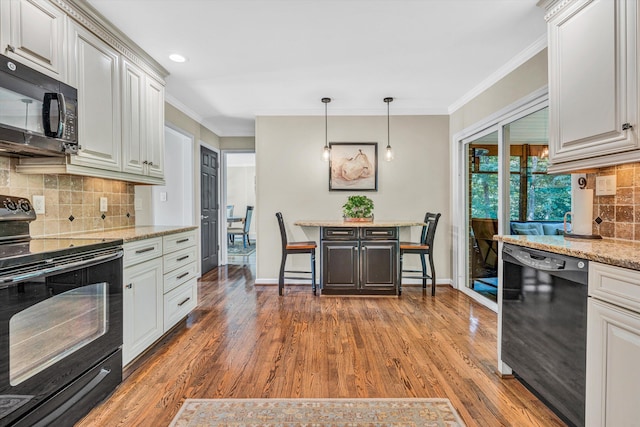134 Sawyer Dr, Salem, VA 24153 - kitchen with black appliances, wood finished floors, backsplash, crown molding, and hanging light fixtures