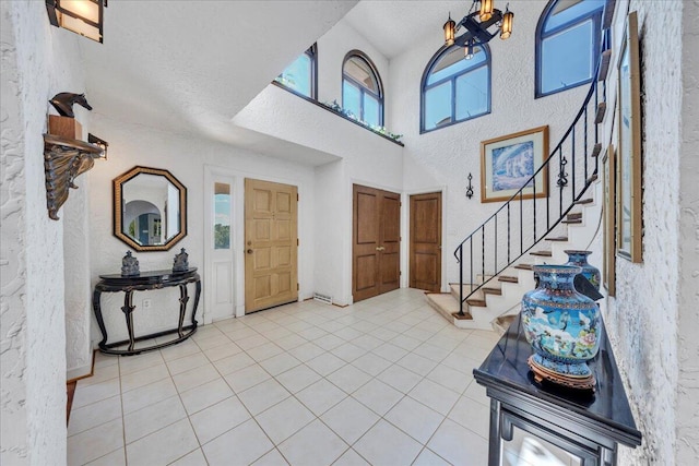 5880 Sugar Loaf Mountain Rd, Roanoke, VA 24018 - entryway with stairs, a textured wall, light tile patterned flooring, a high ceiling, and a chandelier