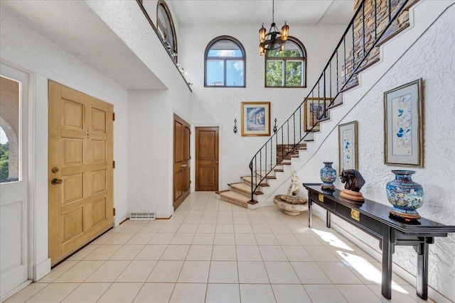 5880 Sugar Loaf Mountain Rd, Roanoke, VA 24018 - foyer with stairway, a chandelier, light tile patterned floors, a textured wall, and a high ceiling